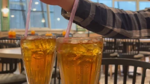 Glasses of Iced Tea on a Restaurant Table with People Stirring in the Background Stock Footage 330145206