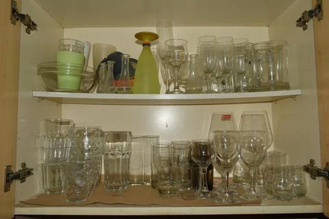 Glasses in a kitchen cabinet  Stock Photos