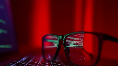 Glasses lie on the laptop keyboard in front of the monitor, the lens reflects a Stock Footage 229850533
