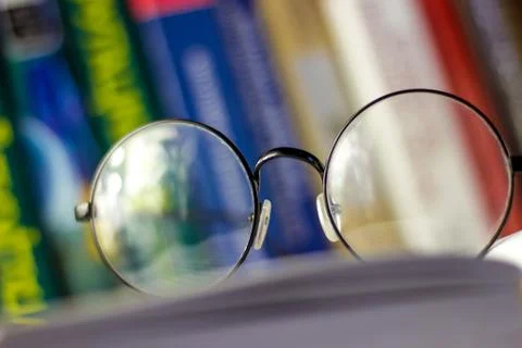 Glasses lie on an open book Stock Photos