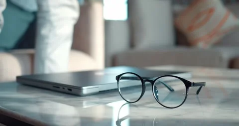 Glasses lie on table and a man closes his laptop and leaves. Workday ends Stock Footage 263178473