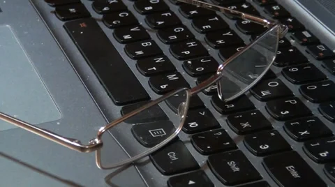 Glasses lying on a keyboard Stock Footage 33754972