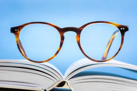 Glasses lying on open book Foto stock
