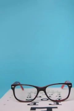 Glasses lying on snellen test chart Stock Photos