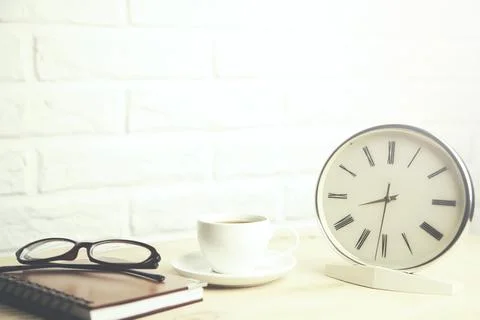 Glasses  on notebook and coffee,clock on table Stock Photos