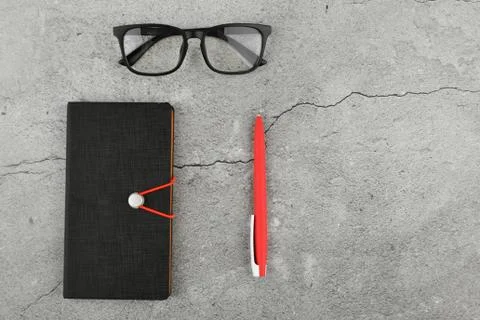 Glasses with notebook on gray background. Office desk with business accessori Foto stock