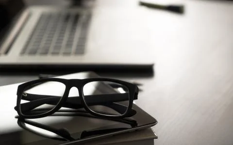 Glasses on office table with computer notebook Stock Photos