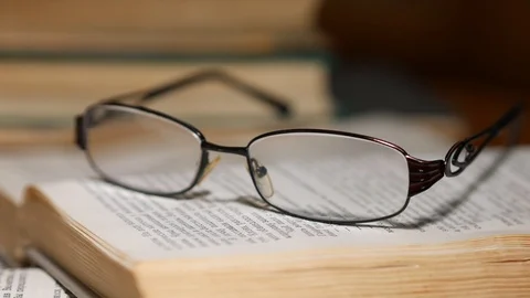 Glasses on the open book. Sliding Stock Footage 93003790
