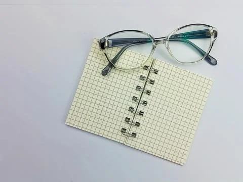 Glasses on open notebook on white background flat lay Stock Photos