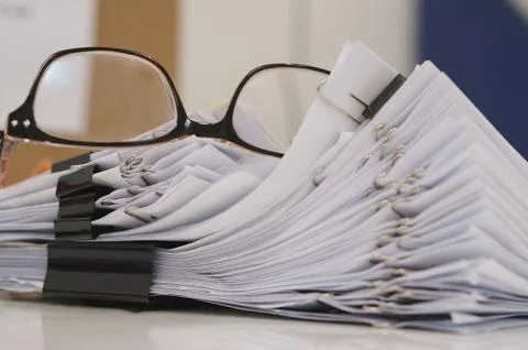 Glasses placed on finished document at workplace in morning Stock Photos