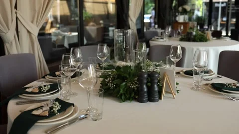 Glasses plates and kitchen utensils on a table in a restaurant for a holiday Stock Footage 311760934