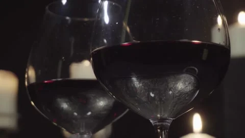 Glasses with red wine on the background of burning candles and Christmas and  Stock Footage 144051460