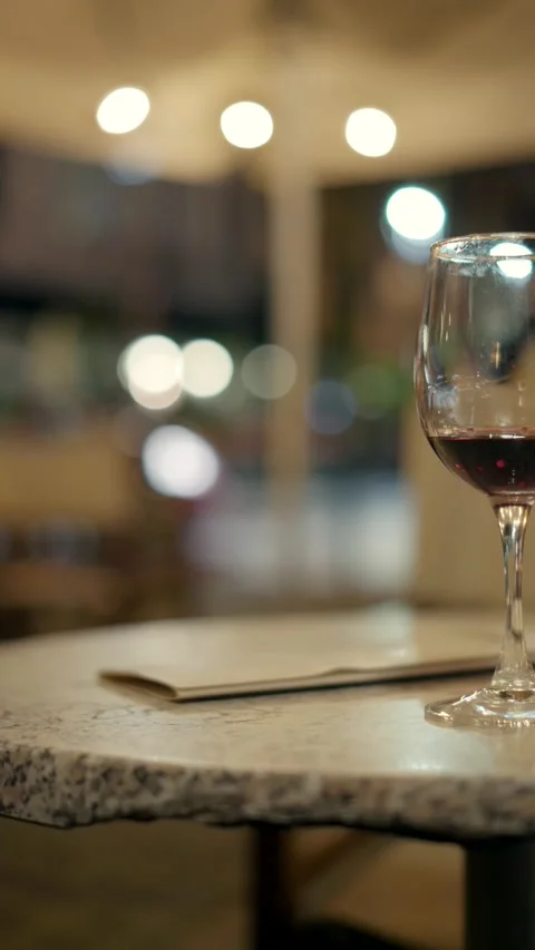 Glasses of red wine on cafe terrace with woman picking glass 動画素材 221581745
