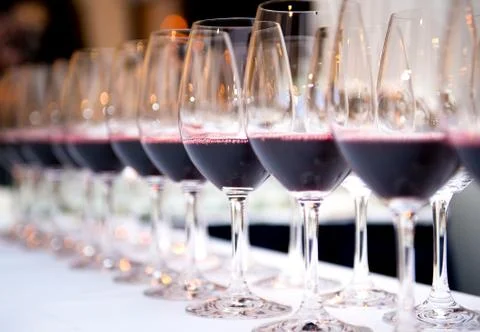 Glasses of red wine in a row on a table Stock Photos