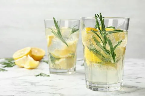Glasses of refreshing lemonade on marble table, space for text. Summer drink Stock Photos