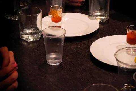 Glasses standing on table while drinking Stock Photos