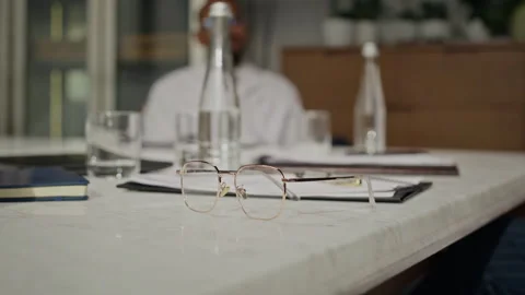 Glasses on Table during Meeting with Blurred Man Stock Footage 337161629