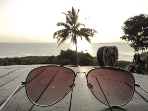 Glasses on table. Palm tree and sunset Foto stock
