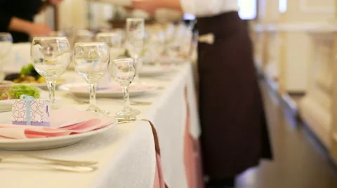 Glasses on table at restaurant and waiters at background Stock Footage 68025821