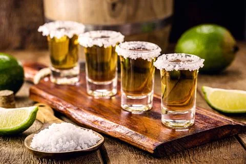 Glasses of tequila on the bar table, served with salt and lemon Stock Photos