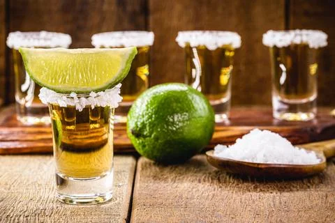 Glasses of tequila on the bar table, served with salt and lemon Stock Photos