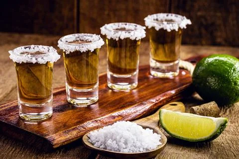 Glasses of tequila on the bar table, served with salt and lemon Stock Photos