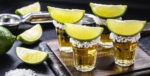 Glasses of tequila on the bar table, served with salt and lemon Stock Photos