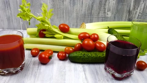 Glasses of tomato, celery, and beets juice stand on a wooden table Stock Footage 171086595