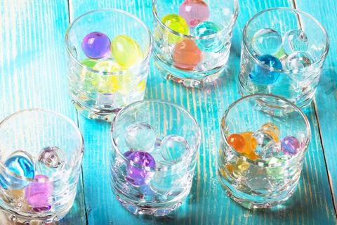 In glasses under alcohol expanded the colored rubber balls Stock Photos