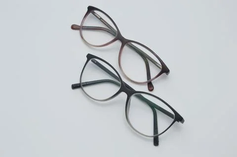 Glasses for vision correction in a dark frame lie on a light background. Stock Photos