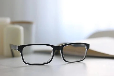Glasses for vision correction on a table in the interior of the room Foto stock