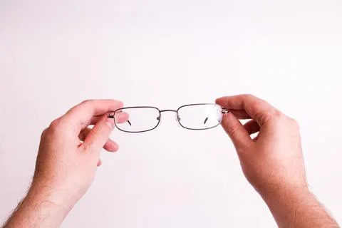 Glasses for vision in hands on gray background Stock Photos