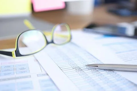 Glasses for vision lying on documents with numbers closeup Stock Photos