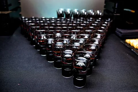 Glasses of whiskey on a buffet table in the form of a triangle. Stock Photos