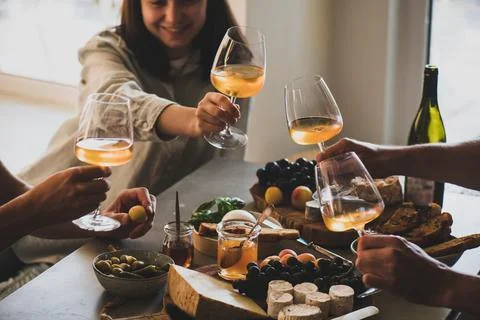 Glasses of white orange or rose wine in peoples hands Stock Photos