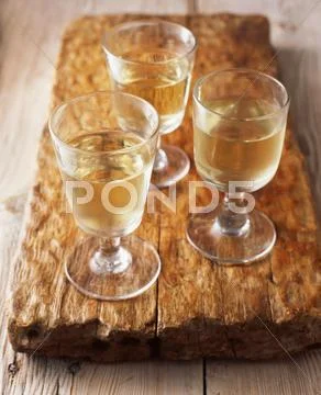 Glasses Of White Wine On Wooden Cutting Board