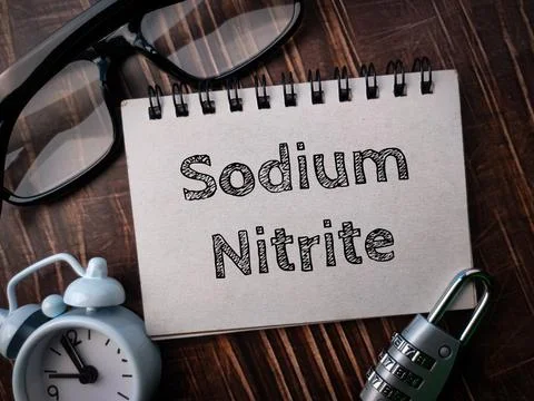 Glasses,clock,padlock and notebook with text Sodium Nitrite Stock Photos