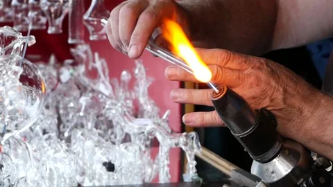 Glassmaker heating the glass for forming with at very high temperature flame. Stock Footage 167659237