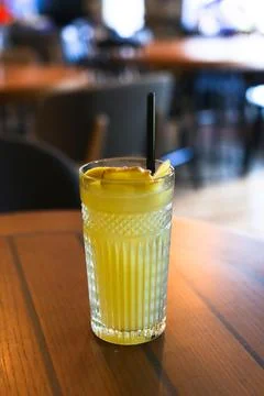 Glassy glass stands on table with drinking straw, which been poured tea Stock Photos