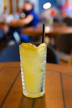 Glassy glass stands on table with drinking straw, which been poured tea Stock Photos
