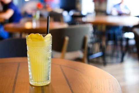 Glassy glass stands on table with drinking straw, which been poured tea Stock Photos