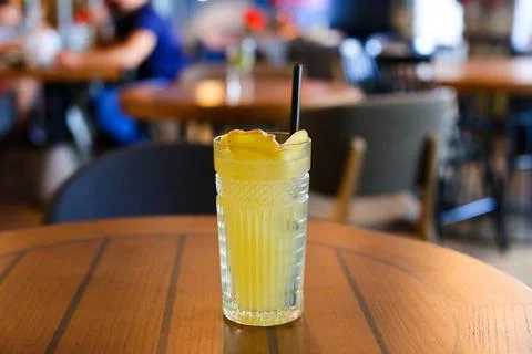 Glassy glass stands on table with drinking straw, which been poured tea Stock Photos