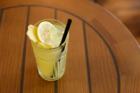 Glassy glass stands on table with drinking straw, which been poured tea Stock Photos