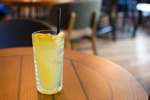 Glassy glass stands on table with drinking straw, which been poured tea Stock Photos