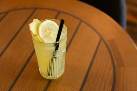 Glassy glass stands on table with drinking straw, which been poured tea Stock Photos