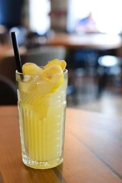 Glassy glass stands on table with drinking straw, which been poured tea Stock Photos