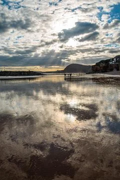 Glassy sunset beach cloud reflections Stock Photos