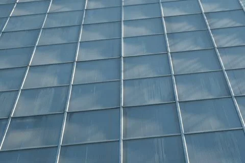 Glassy surface reflecting clouds on a sunny day in urban setting Foto stock