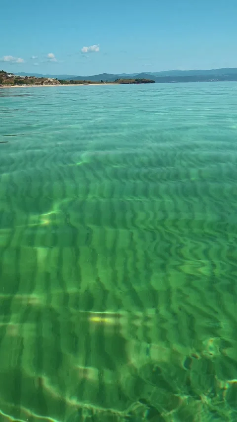 Glassy waves ripple under bright sunlight. Trani Ammouda, Greece. Vertical Stock Footage 338358186