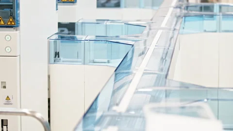 A glazed automated lab line with empty test tube holders moving in the Stock Footage 233128401